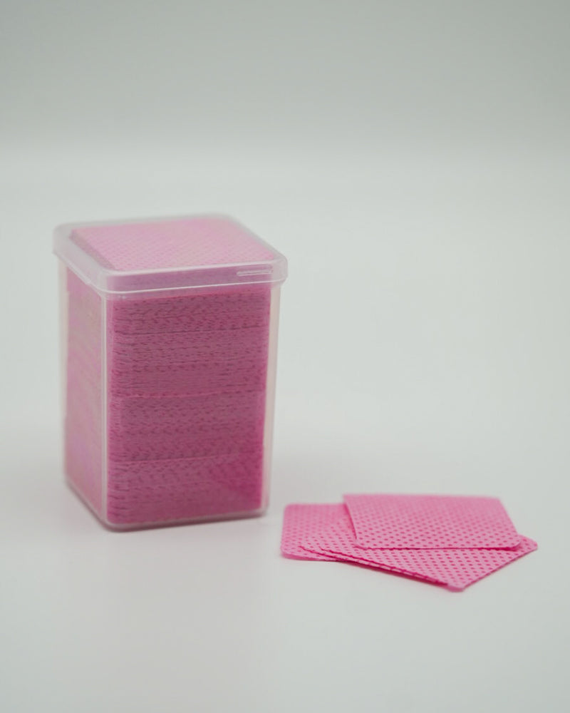 Produktaufnahme der Sheesh Nails Fussel- und staubfreien Zellstoff-Pads in zartem Rosa. Die Pads sind ordentlich in einer transparenten Box gestapelt und zeigen ihre fein strukturierte Oberfläche. Sie eignen sich ideal zur gründlichen Reinigung und Vorbereitung der Nägel vor dem Auftragen der UV-Nagelfolien. Das hochwertige, fusselfreie Zellstoffmaterial sorgt für eine hygienische Anwendung und ein perfektes, professionelles Ergebnis bei jeder Maniküre oder Pediküre.