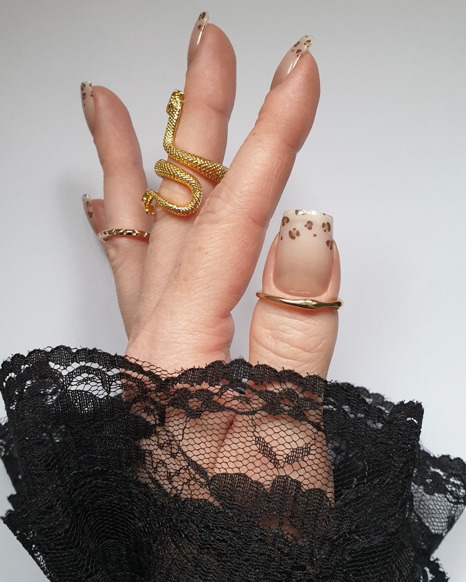 Hand trägt die Sheesh Nails UV-Nagelfolie Half Life. Die Folien zeigen ein transparentes Design mit feinem Leopardenmuster in Braun- und Beigetönen auf zartem Nude-Hintergrund. Der Look wirkt elegant, modern und leicht verspielt – perfekt für trendige Animal-Print-Maniküren mit stilvollem Finish.