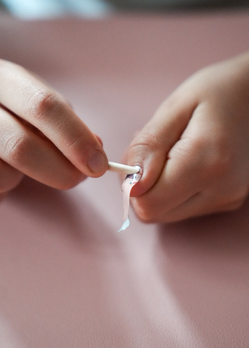 Nahaufnahme einer Kinderhand mit den Sheesh Nails Kinder-Nagelfolien „Butterfly“. Die selbstklebenden Sticker zeigen ein verspieltes Design mit bunten Schmetterlingen und Blüten auf rosafarbenem Grund. Das deckende Finish sorgt für einen fröhlichen, kindgerechten Look. Hautfreundlich, ungiftig und leicht anzubringen – ideal für kreative Kinder-Maniküren mit Farbe und Fantasie.