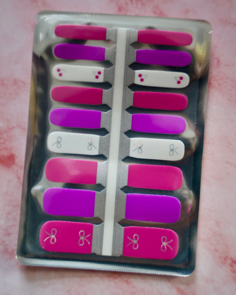 SHEESH Nails Nagelfolien Cherry Bow in Pink und Weiß mit kleinen Schleifen- und Kirschenmotiven – süßes Nageldesign für Kinder.