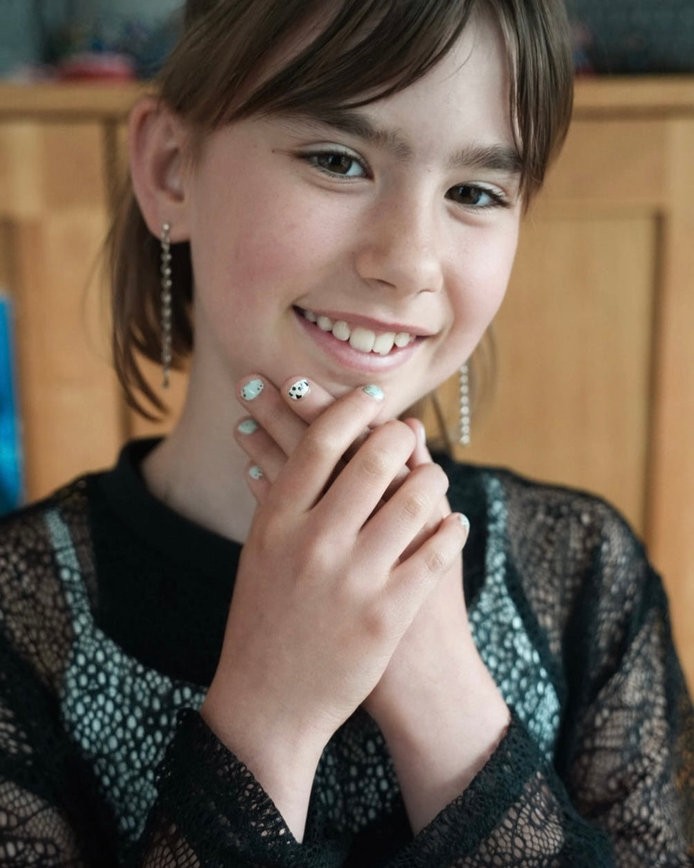 Nahaufnahme eines Kindes mit Sheesh Nails Kinder-Nagelfolien „Panda“. Die Nägel sind mit süßen Pandabären-Designs in Weiß und Grün verziert. Das Motiv wirkt freundlich und verspielt, perfekt für eine fröhliche, kindgerechte Maniküre. Die Folien sind hautfreundlich, ungiftig und leicht anzubringen – ideal für kreative Kinder-Maniküren mit Tiermotiven.