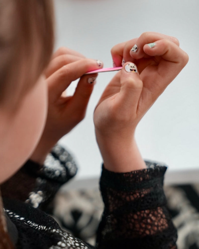 Nahaufnahme einer Kinderhand mit Sheesh Nails Kinder-Nagelfolien „Panda“. Die selbstklebenden Sticker zeigen süße Pandabären und Bambusmotive in Grün und Weiß. Das verspielte Design sorgt für einen freundlichen, kindgerechten Look. Die Folien sind hautfreundlich, ungiftig und leicht anzubringen – ideal für kreative Kinder-Maniküren mit Tiermotiven.