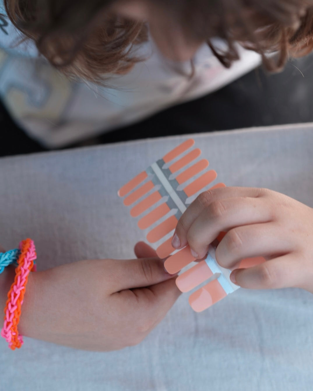 Nahaufnahme einer Kinderhand mit den Sheesh Nails Kinder-Nagelfolien „Peach“. Die zarten Pfirsichfarben verleihen kleinen Nägeln einen weichen, natürlichen Look. Die selbstklebenden, deckenden Sticker lassen sich leicht aufkleben und rückstandsfrei wieder entfernen – ganz ohne UV-Lampe. Das Design wirkt warm, freundlich und sorgt für eine gepflegte Kinder-Maniküre mit sanftem Glanz. Hautfreundlich, ungiftig und perfekt für kreative kleine Nail-Artists.