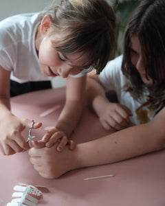 Nahaufnahme einer Kinderhand mit den Sheesh Nails Kinder-Nagelfolien „Schmetterling“. Die selbstklebenden Sticker zeigen ein verspieltes Design mit bunten Schmetterlingen auf rosafarbenem Hintergrund. Das deckende Finish sorgt für einen fröhlichen, kindgerechten Look. Hautfreundlich, ungiftig und leicht anzubringen – ideal für kreative Kinder-Maniküren voller Farbe und Fantasie.