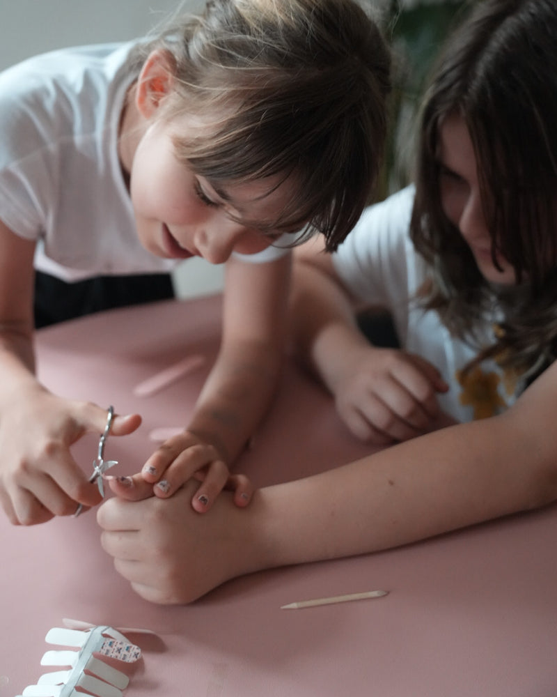 Nahaufnahme einer Kinderhand mit den Sheesh Nails Kinder-Nagelfolien „Schmetterling“. Die selbstklebenden Sticker zeigen ein verspieltes Design mit bunten Schmetterlingen auf rosafarbenem Hintergrund. Das deckende Finish sorgt für einen fröhlichen, kindgerechten Look. Hautfreundlich, ungiftig und leicht anzubringen – ideal für kreative Kinder-Maniküren voller Farbe und Fantasie.