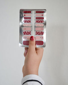 Kinderhand hät Nagelfolie von SHEESH. Rote und rosafarbene Kinder-Nagelfolien mit Schneemann- und Schneeflocken-Motiv – weihnachtliches Winter Nail Design für Kinderhände.