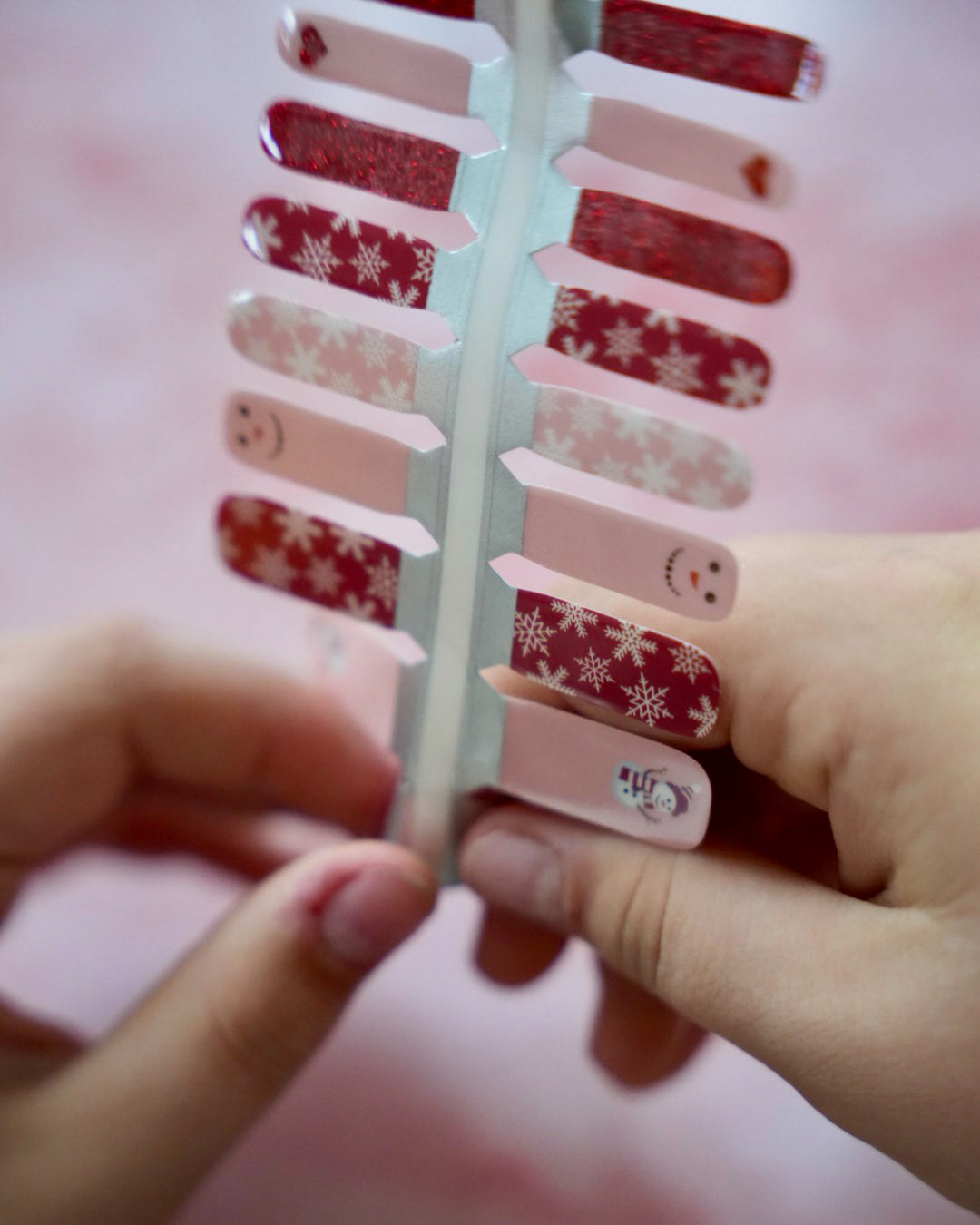 Rote und rosafarbene Kinder-Nagelfolien mit Schneemann- und Schneeflocken-Motiv von SHEESH Nails – weihnachtliches Winter Nail Design für Kinderhände.
