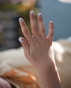 Nahaufnahme einer Kinderhand mit den Sheesh Nails Kinder-Nagelfolien „Süßes Früchtchen“. Die selbstklebenden Sticker zeigen ein sommerlich-verspieltes Design mit roten Erdbeeren auf hellblauem Grund. Das fröhliche Motiv sorgt für gute Laune und bringt Farbe in jede Kinder-Maniküre. Die Folien sind deckend, leicht anzubringen und rückstandsfrei wieder zu entfernen – ganz ohne UV-Lampe. Hautfreundlich, ungiftig und perfekt für kreative kleine Nail-Artists, die Spaß an bunten Designs haben.