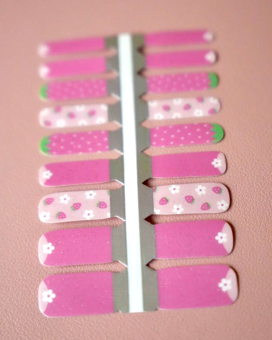 Sheesh Nails Kinder-Nagelfolien „Süßes Früchtchen“ bringen sommerlich-fruchtige Motive auf kleine Nägel. Das verspielte Design mit roten Erdbeeren auf hellblauem Hintergrund sorgt für gute Laune und macht jede Kinder-Maniküre zu einem fröhlichen Hingucker. Die transparenten Sticker-Folien lassen sich kinderleicht aufkleben und rückstandsfrei wieder entfernen – ganz ohne UV-Lampe oder zusätzliche Hilfsmittel. Hautfreundlich, ungiftig und perfekt für kreative kleine Nail-Artists, die Spaß an Farbe und Fantasi