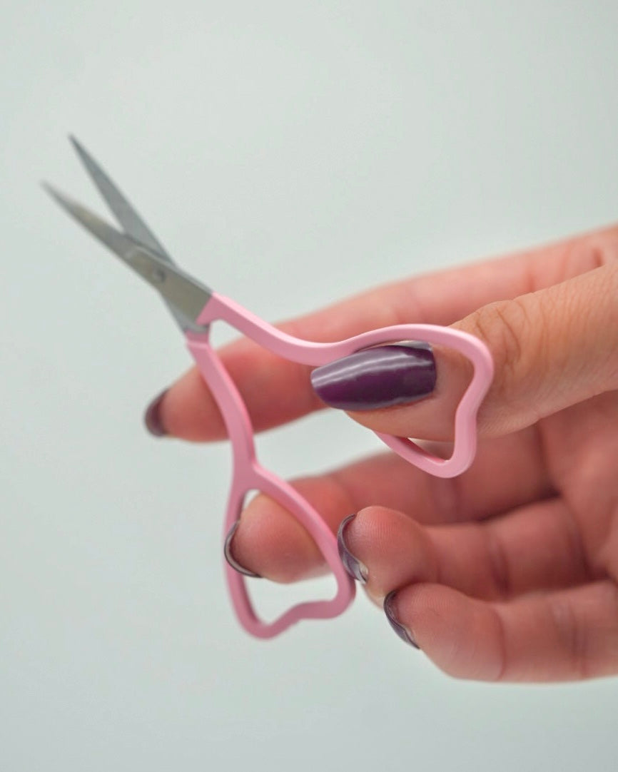 Feine Sheesh Nails Nagelschere in elegantem Rosa mit ergonomisch geformten Griffen in Herzform. Ideal zum präzisen Kürzen von Nagelfolien, Cuticles und Feinarbeiten bei Maniküre und Pediküre. Die handliche Schere überzeugt durch hochwertige Verarbeitung, präzise Schneiden und ein modernes Beauty-Design – perfekt für den professionellen oder privaten Gebrauch.