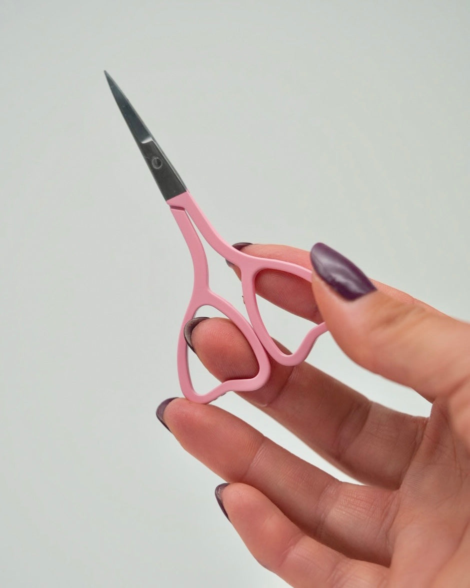 Feine Sheesh Nails Nagelschere in elegantem Rosa mit ergonomisch geformten Griffen in Herzform. Ideal zum präzisen Kürzen von Nagelfolien, Cuticles und Feinarbeiten bei Maniküre und Pediküre. Die handliche Schere überzeugt durch hochwertige Verarbeitung, präzise Schneiden und ein modernes Beauty-Design – perfekt für den professionellen oder privaten Gebrauch.