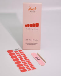 Produktaufnahme der Sheesh Nails Pedi UV-Nagelfolie „Blood Orange Mimosa“. Die Verpackung zeigt das elegante Design in Korallrot-Orange, kombiniert mit Feile und Folienbogen. Das Bild vermittelt Qualität, Frische und sommerliche Energie – ideal für eine moderne, gepflegte Pediküre im leuchtenden Statement-Look.