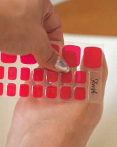 Set der Sheesh Nails Pedi UV-Nagelfolien „Lifeguard“. Die kräftig roten Folien verleihen den Fußnägeln einen intensiven, glänzenden Look mit sommerlicher Ausstrahlung. Sie lassen sich leicht auftragen und unter UV-Licht aushärten – ideal für eine gepflegte Pediküre mit leuchtendem Statement-Finish, perfekt für den Sommer.
