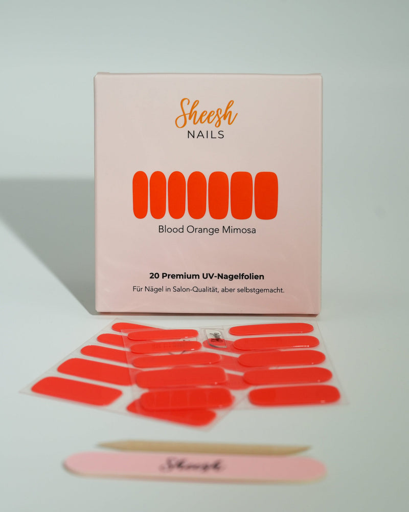 Produktfoto der Sheesh Nails UV-Nagelfolien „Blood Orange Mimosa“. Die selbstklebenden Folien in leuchtendem Orange setzen ein kräftiges Farbstatement und sorgen für einen sommerlich-frischen Look in Salonqualität. Im Vordergrund liegen die geöffneten Folien und eine Sheesh-Nagelfeile – ideal für auffällige, energiegeladene Maniküren mit Glanzfinish.