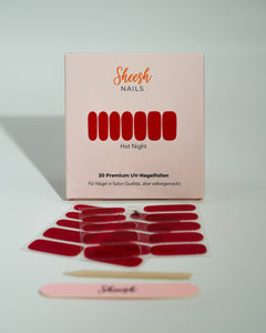 Produktfoto der Sheesh Nails UV-Nagelfolien „Hot Night“. Die selbstklebenden Folien in intensivem Rot verleihen den Nägeln einen eleganten, glänzenden Look in Salonqualität. Im Vordergrund liegen die geöffneten Folien und eine Sheesh-Nagelfeile – ideal für ausdrucksstarke, klassische Maniküren mit Glamour-Faktor.