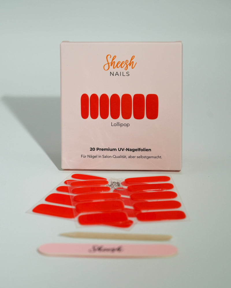Produktfoto der Sheesh Nails UV-Nagelfolien „Lollipop“. Die selbstklebenden Folien in kräftigem Rot verleihen den Nägeln einen auffälligen, hochglänzenden Look in Salonqualität. Im Vordergrund liegen die geöffneten Folien und eine Sheesh-Nagelfeile – perfekt für energiegeladene, moderne Maniküren mit Statement-Farbe.