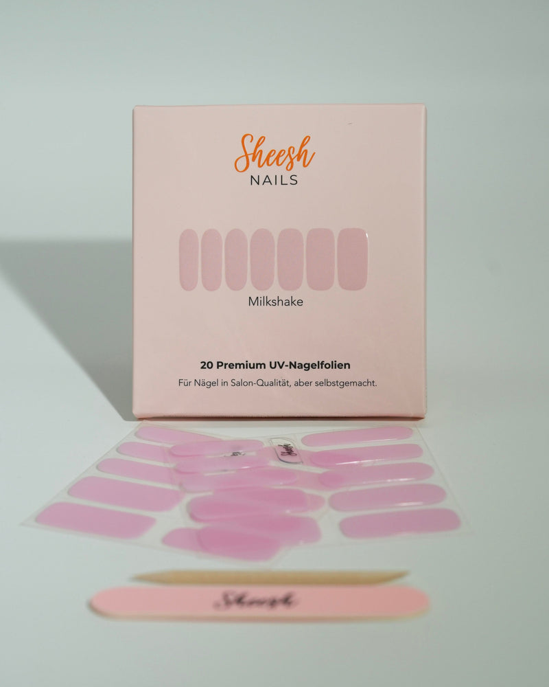 Produktfoto der Sheesh Nails UV-Nagelfolien „Milkshake“. Die selbstklebenden Folien in zartem Rosa verleihen den Nägeln einen sanften, glänzenden Look in Salonqualität. Im Vordergrund liegen die geöffneten Folien und eine Sheesh-Nagelfeile – perfekt für feminine, natürliche Maniküren mit einem Hauch Eleganz.