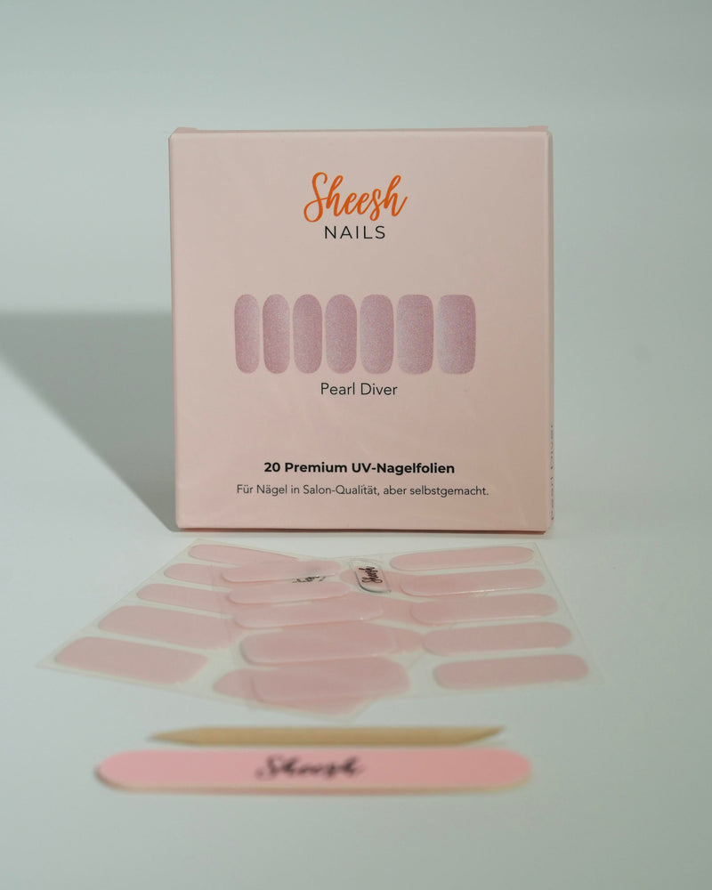 Produktfoto der Sheesh Nails UV-Nagelfolien „Pearl Diver“. Die selbstklebenden Folien in schimmerndem Rosé mit feinem Glitzereffekt verleihen den Nägeln einen eleganten, perlmuttartigen Look in Salonqualität. Im Vordergrund liegen die geöffneten Folien und eine Sheesh-Nagelfeile – ideal für festliche, feminine Maniküren mit edlem Glanz.