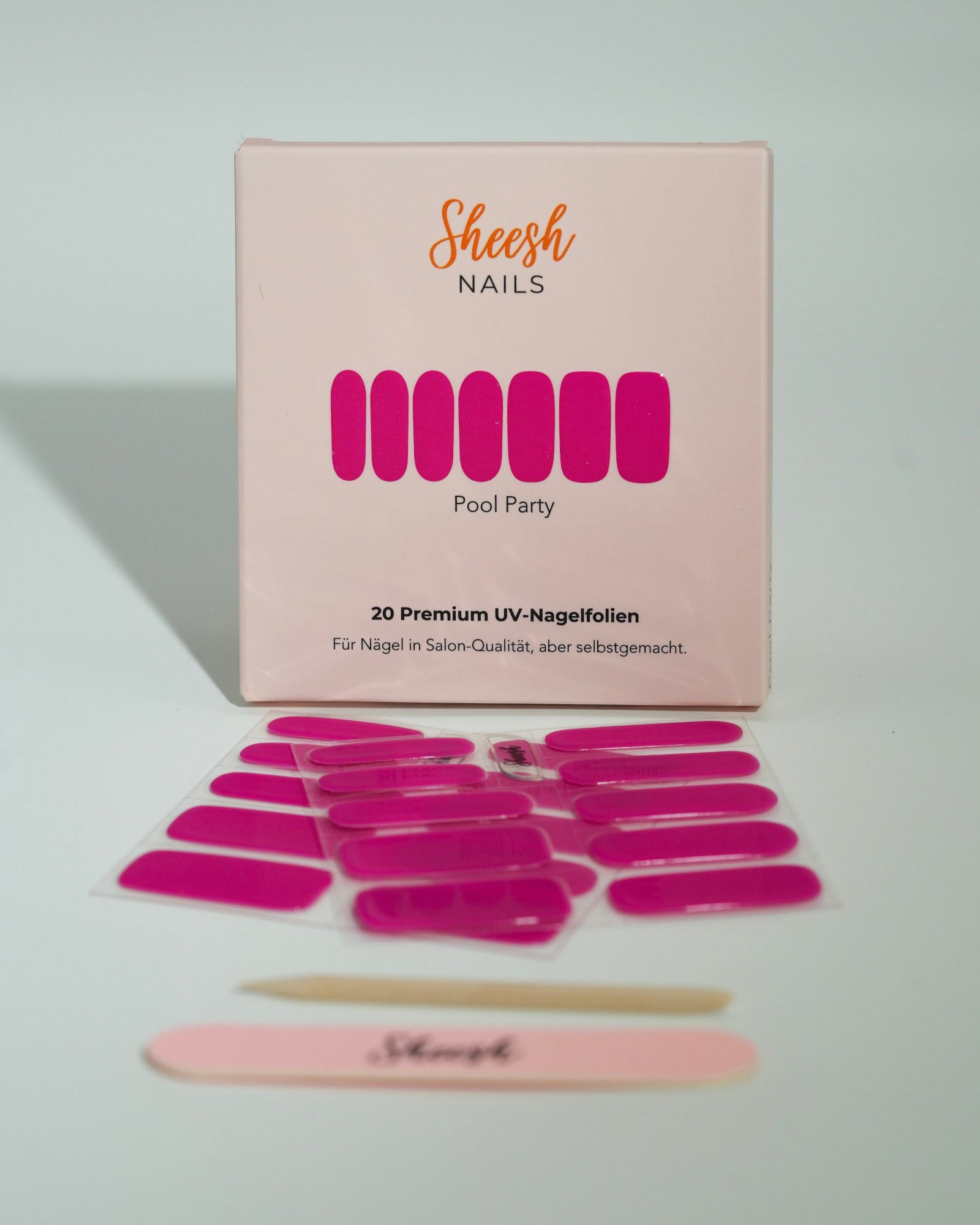 Produktfoto der Sheesh Nails UV-Nagelfolien „Pool Party“. Die selbstklebenden Folien in leuchtendem Pink sorgen für einen auffälligen, glänzenden Look in Salonqualität. Im Vordergrund liegen die geöffneten Folien und eine Sheesh-Nagelfeile – perfekt für trendige, sommerliche Maniküren mit Statement-Farbe.