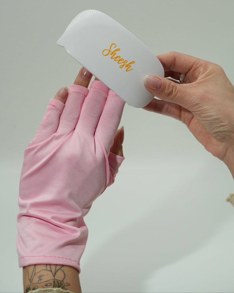 Sheesh Nails UV-Schutz Handschuhe in zartem Rosa schützen die Hände zuverlässig vor UV-Licht während der Nagelmodellage oder beim Aushärten unter der UV-Lampe. Das hochwertige, atmungsaktive Material sorgt für ein angenehmes Tragegefühl und verhindert Hautalterung durch UV-Strahlung. Ideal für professionelle Nagelstudios oder die sichere Maniküre zu Hause – stilvoll, funktional und im typischen Sheesh Nails Look.