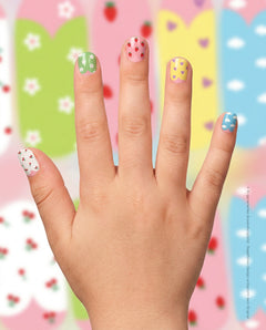 SHEESH Nails – Taylor, Bild 01: Kinderhand mit bunten Taylor Nagelfolien in verschiedenen Motiven vor weich verschwommenem Designhintergrund.