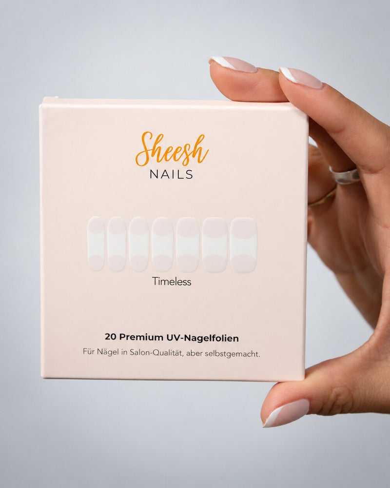 SHEESH Nails – Timeless UV-Nagelfolien, Bild 02: Timeless-Verpackung mit French-Nageldesign in einer Hand.